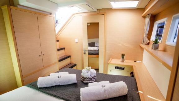 Comfortable bedroom on Catamaran Lucky Clover with direct deck access and stylish interior.