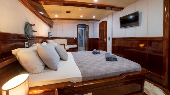 Cosy double cabin on a motor sailer with 5 cabins in Fethiye, equipped with modern amenities and elegant wood panelling.