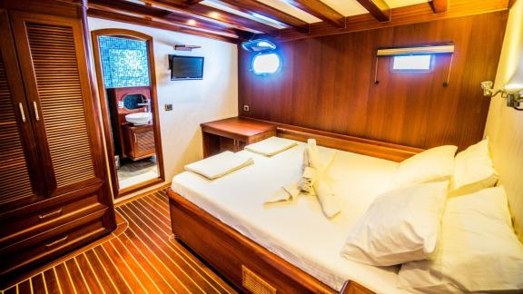 Stylish and cosy cabin of the Gulet Freedom in Marmaris, with private bathroom and elegant wooden accents.