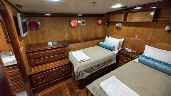 Comfortable cabin with two single beds and private bathroom on the Kayhan yacht, perfect for family members.