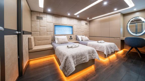 Das Gästezimmer der North Wind mit zwei Einzelbetten, stilvoller Beleuchtung und modernem Design.