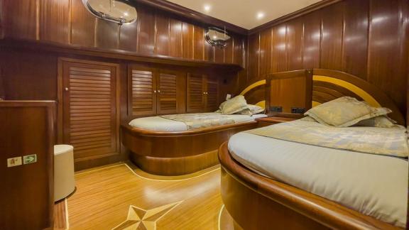 Cozy cabin with two single beds and stylish wooden furniture on the Gulet Diva Deniz.