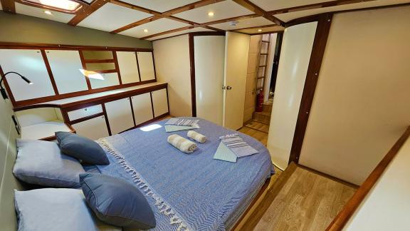 Spacious guest cabin on Gulet Arni with a comfortable bed and practical storage.