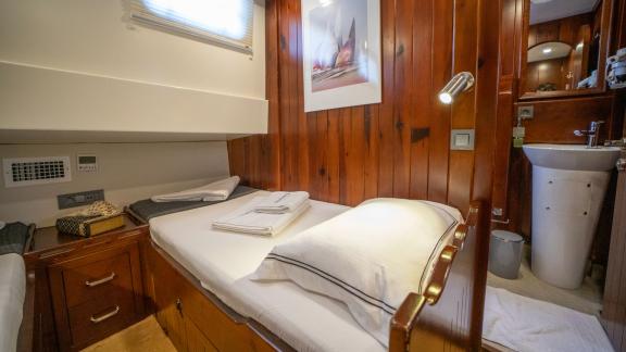 Comfortable single cabin of the luxurious Gulet Uluçınar in Bodrum, Turkey, with en-suite bathroom.