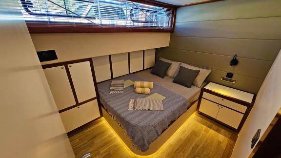 Inviting guest cabin on Gulet Arni with warm lighting and comfortable bed.