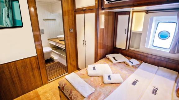 The comfortable guest cabin of Maske 2 features a cozy bed and a private bathroom.