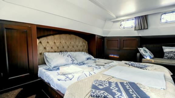 Elegante Kabine mit komfortablem Bett auf der Yacht Angel V, ideal für erholsame Nächte auf See.