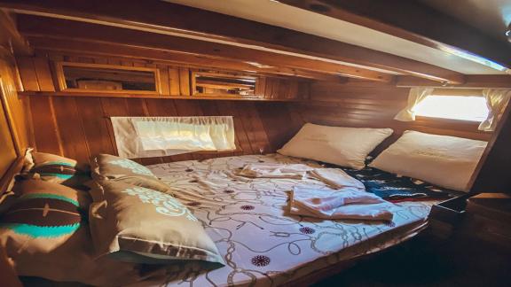 Cozy sleeping cabin with double bed and wooden walls. Perfect for restful nights at sea.