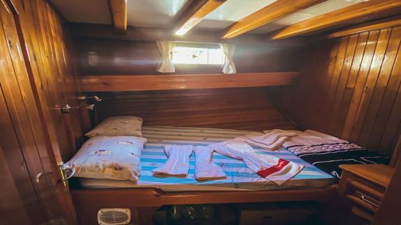 Small but cozy: Comfortable cabin with single bed and wooden walls. Perfect for quiet nights at sea.