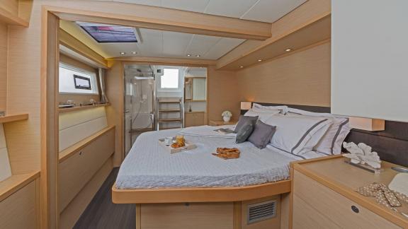 The master cabin on Lagoon 560 S2 Meliti with a large double bed and private access to the bathroom