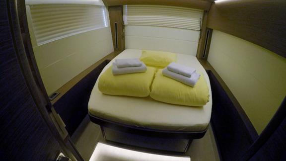 A stylish cabin on the Lagoon 50, featuring a soft double bed and pleasant lighting for added comfort.