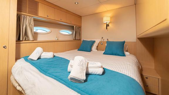 Elegantes Schlafzimmer auf der Yacht Stela 117 mit blauen Akzenten in der Dekoration.