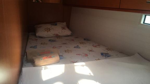 Another single cabin on the sailing yacht Santiago with maritime-themed bedding.