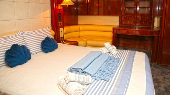 Das luxuriöse Schlafzimmer der Motoryacht Consent 24 in Bodrum bietet ein großes Bett und eine gemütliche Sitzecke.