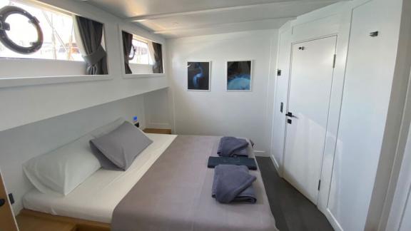 Moderne Kabine mit Doppelbett, drei Bullaugenfenstern und minimalistischer Dekoration auf der Gulet Albatros M.