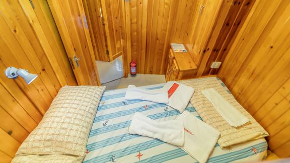 Cabin with wooden walls and soft towels. Perfect for restful nights onboard.