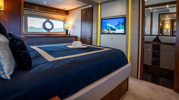 Das moderne Schlafzimmer der Yacht Goldeneye ist mit einem großen Bett und einem integrierten Fernseher ausgestattet.