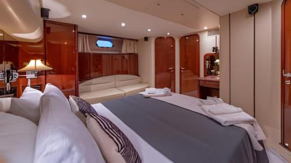 The master cabin of the motor yacht Ibiza features a large bed and a comfortable seating area.