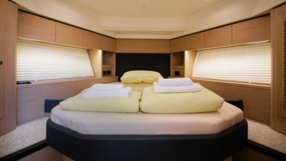 The bedroom on the motor yacht Ocean Dreamer features a large and comfortable bed, modern decor.