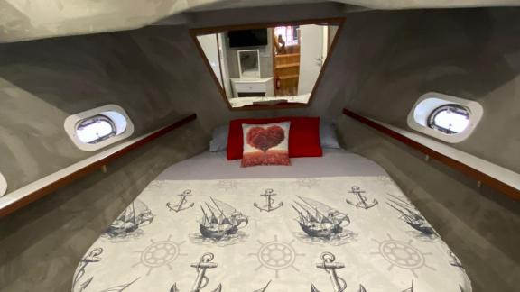 The master cabin of the motor yacht Niloş offers a comfortable retreat with nautical-themed decor and a spacious bed.