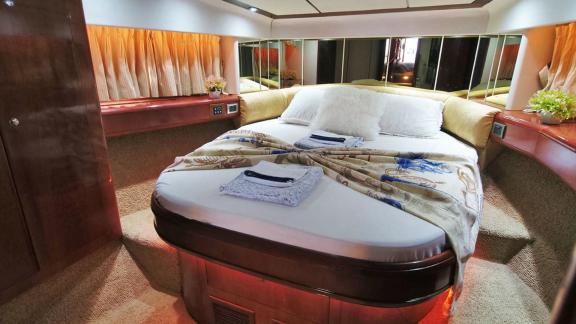 Luxurious master cabin of the motor yacht Queen with a comfortable bed and stylish decor.