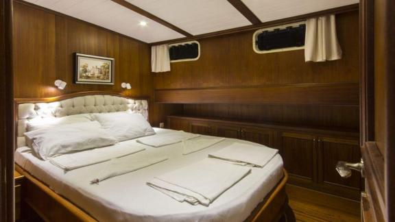 Double cabin on Gulet Cemre 4 with wooden decor and a comfortable bed.