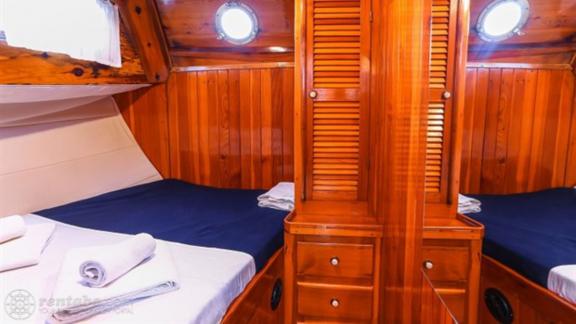 The cabin on Gulet Aurora with two beds is designed with wooden elements and offers comfort.