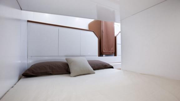 The bedroom of the Neve motor yacht features a simple and modern bed.