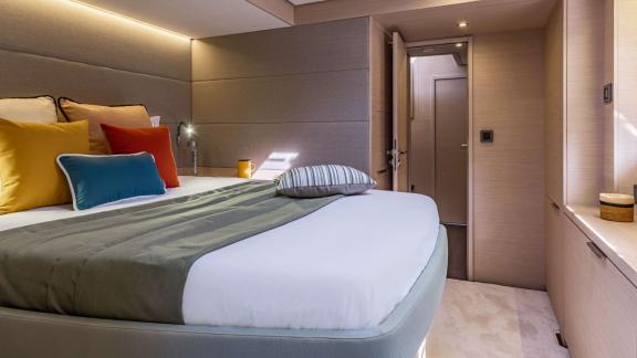 Modern bedroom of catamaran Happy decorated with colorful pillows.