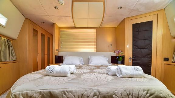 Komfortables Schlafzimmer auf der Yacht Stela 117 mit großem Bett und gemütlicher Dekoration.