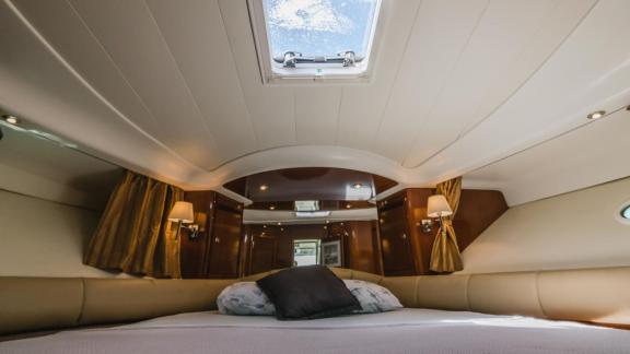 The bedroom of motor yacht Unplugged provides a cozy sleeping area with a skylight.