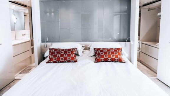 The double bedroom on motor yacht Coco De Mer offers comfort and luxury with elegant pillows and modern design.