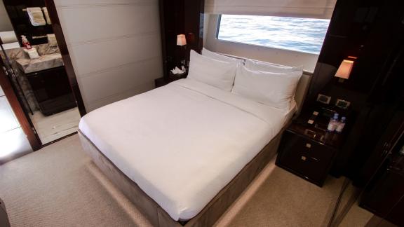 The guest bedroom of the Legende motor yacht, featuring a sea-view design, adds luxury and comfort to your Dubai yacht r