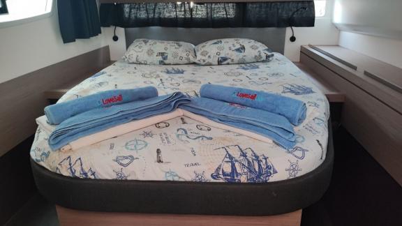 Das Doppelbett im Kabinenbereich des Katamarans Blue Orion ist mit maritimem Bettzeug ausgestattet.