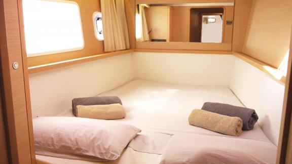 The cozy cabin of the Balok catamaran features a spacious bed and windows allowing natural light for maximum comfort.