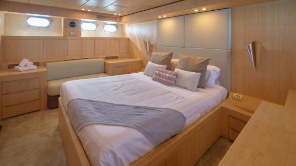 Die helle Kabine der Yacht Zazzazu verfügt über ein großes Bett, Sitzgelegenheit und Fenster. Ideal für Chartergäste.