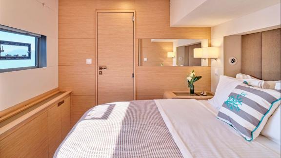 The guest room of the Sunmoon yacht creates a relaxing atmosphere with wooden details and a bright window.