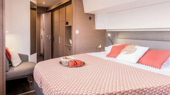 The catamaran Kebisiks offers a wide bed, armchair, and tea tray in a bright cabin near Athens.