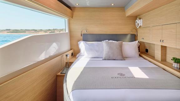 Kabine mit Meerblick, Doppelbett und eleganten Holzakzenten.