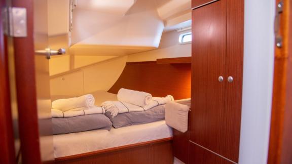 The double cabin on the Beau Gosse sailing yacht features a comfortable bed and storage space.