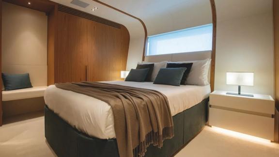 Wood-accented guest cabin with double bed aboard Dawo motor yacht, currently docked in Sibenik.