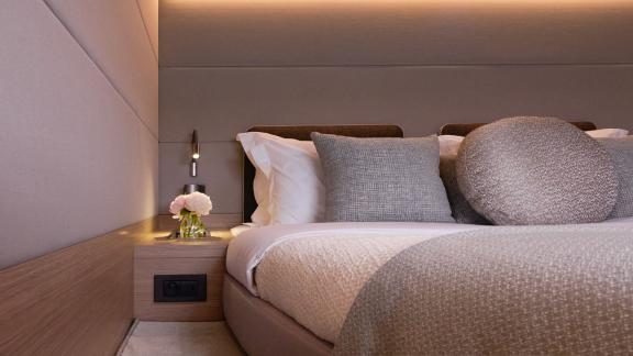 The cabin of Dream catamaran features soft tones, textured bedding and warm lighting creating a peaceful ambiance.