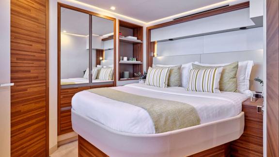 Cabin includes a mirrored closet, shelves and a soft bed with striped pillows.