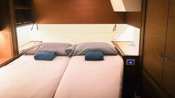 The Akana cabin features two pushed-together beds, reading lights and wood finishes.