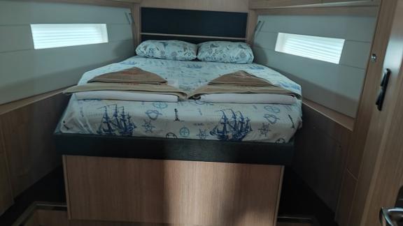 Comfortable double cabin on the sailing yacht Blue Monkey with maritime-themed bedding.