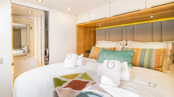 The Vulpino cabin in Kastela features a large bed colorful pillows and private bathroom.