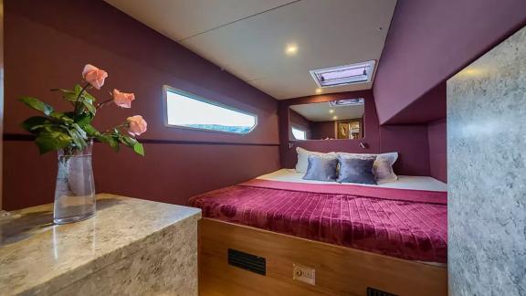 Luna 49 Blue kabininde yatak üstü pencere, uzun yan cam ve şarap tonlarında dekorasyonla huzurlu bir ortam sunuluyor.