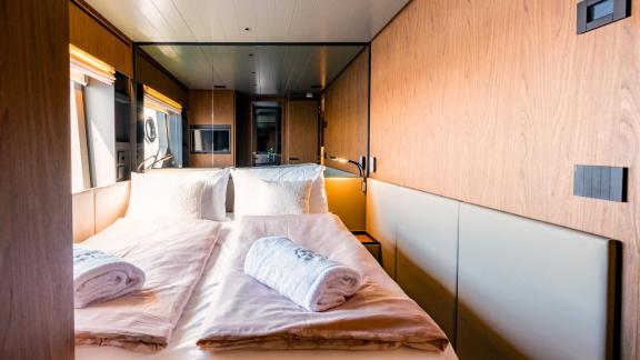 Motor yacht Kimani Bluegame BG74 features a warm‑toned cabin designed with a comfortable double berth setup for restful