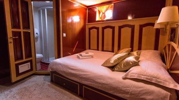 Korab motor yacht offers a cozy cabin with private bathroom and wood-detailed walls.