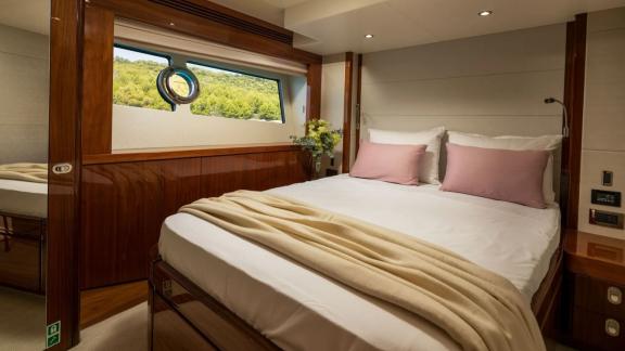 The Sunseeker 75 features a serene guest cabin with forest view, cozy lighting and a spacious double bed.